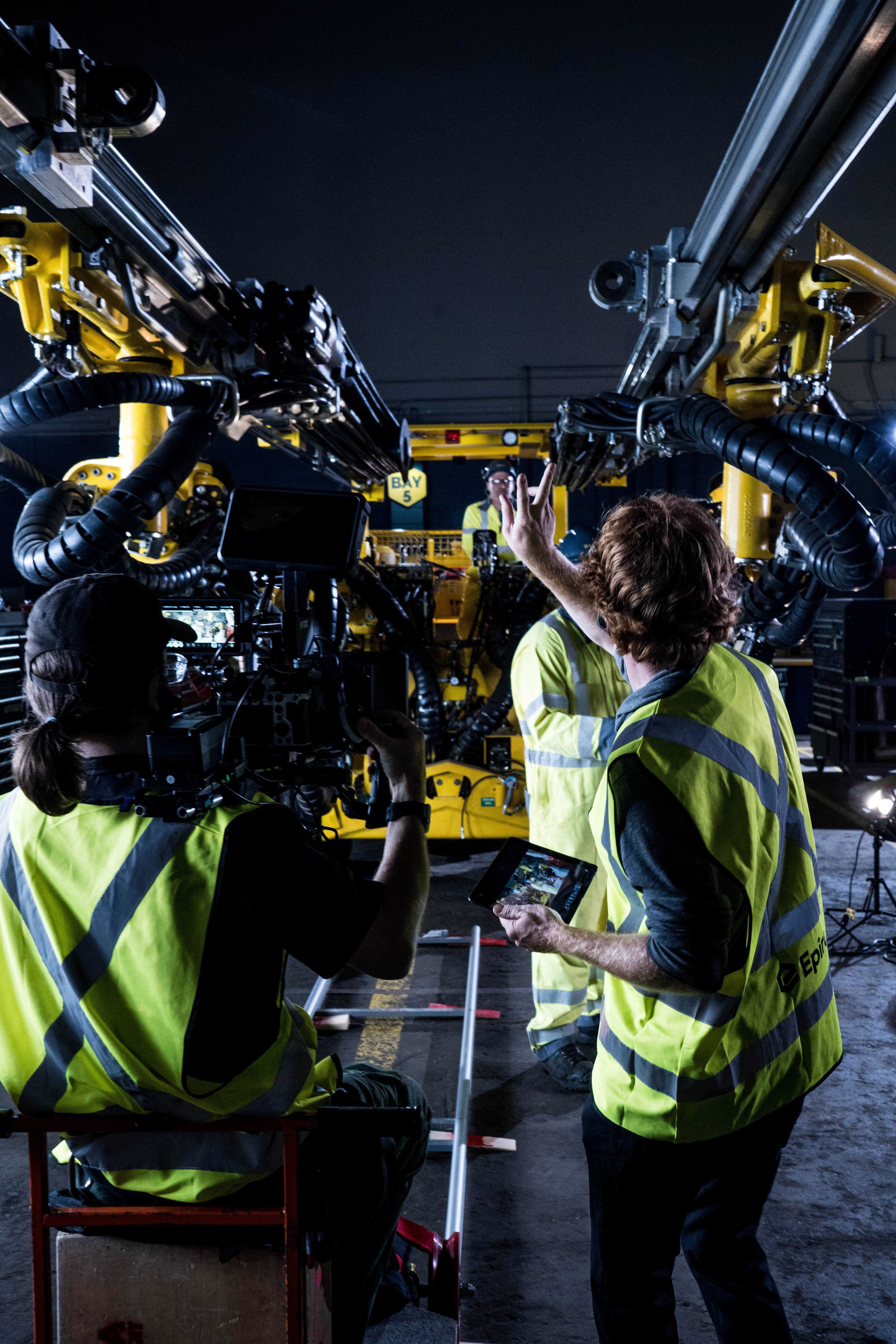 Crew filming inside an industrial bay